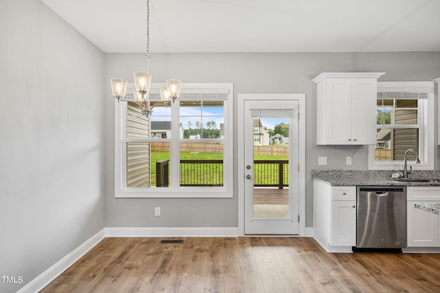 unfurnished dining area featuring sink, a notable chandelier, and light wood-type flooring