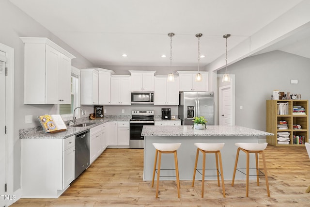 kitchen featuring white cabinetry, stainless steel appliances, a center island, and sink