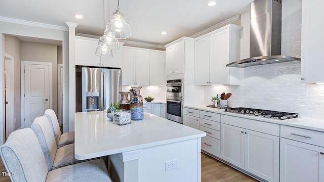 kitchen with wall chimney exhaust hood, stainless steel appliances, and white cabinetry