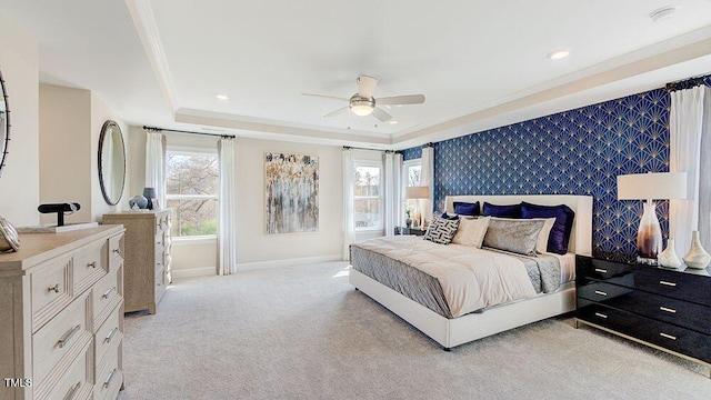 bedroom with ceiling fan, light colored carpet, ornamental molding, and a raised ceiling