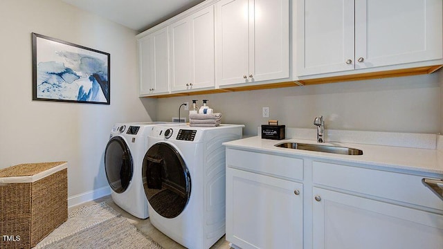 washroom featuring cabinets, washer and clothes dryer, and sink