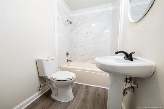 bathroom featuring hardwood / wood-style flooring, toilet, crown molding, and tiled shower / bath