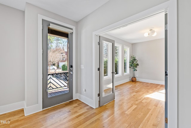 entryway with light wood finished floors and baseboards