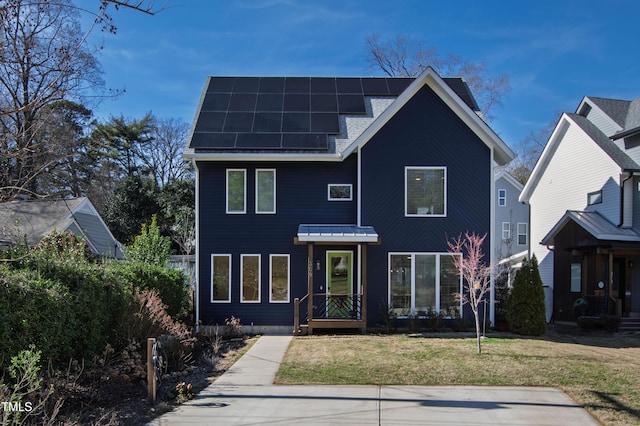 view of front of house with a front yard and roof mounted solar panels