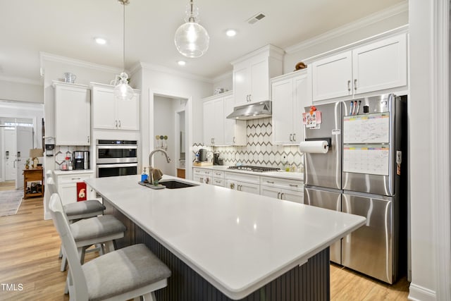 kitchen featuring sink, white cabinets, a center island with sink, and stainless steel appliances