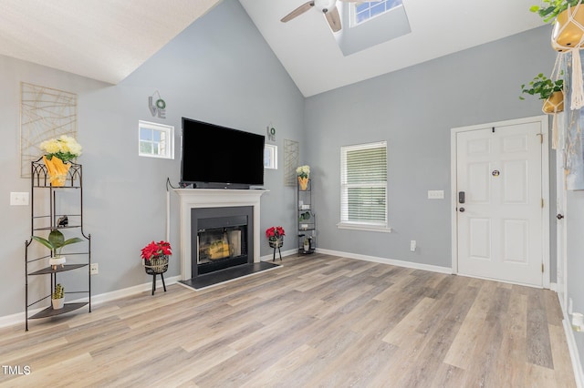 living room with high vaulted ceiling, light wood-type flooring, and ceiling fan