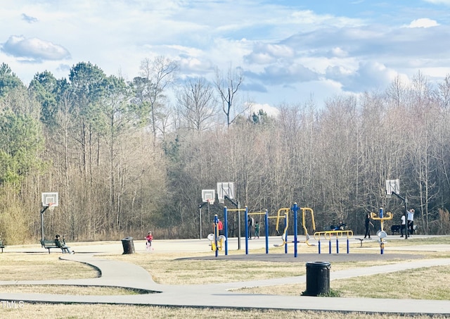 surrounding community with playground community, community basketball court, and a wooded view