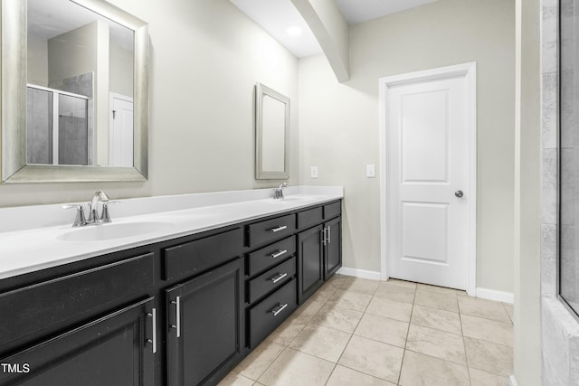 bathroom featuring tile patterned floors, vanity, and a shower with door