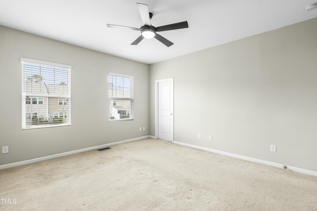 empty room featuring light colored carpet and ceiling fan