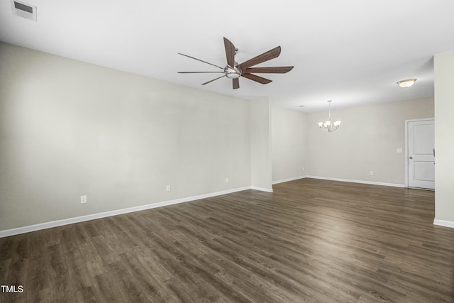 empty room with dark wood-type flooring and ceiling fan with notable chandelier