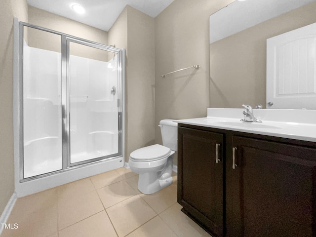 bathroom featuring tile patterned floors, toilet, walk in shower, and vanity