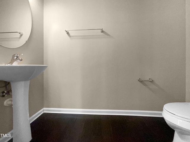 bathroom featuring toilet and wood-type flooring