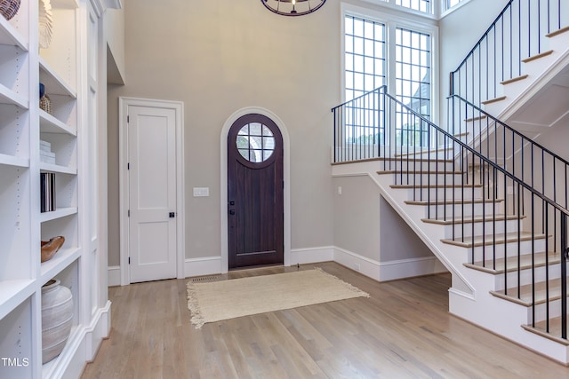 entryway with light wood-type flooring and a high ceiling