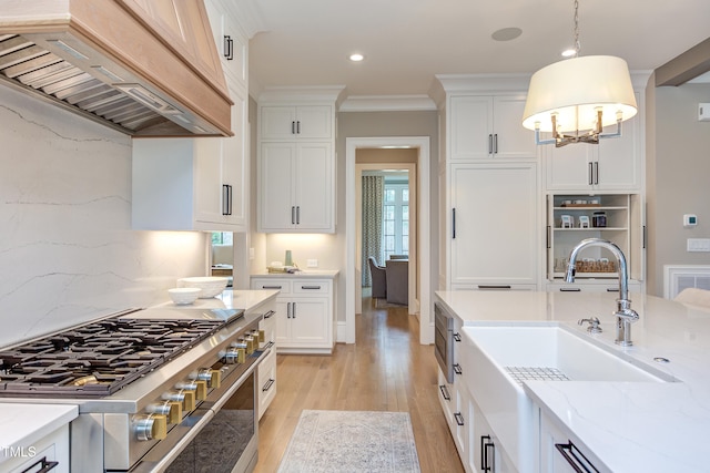 kitchen featuring white cabinetry, decorative light fixtures, and custom range hood