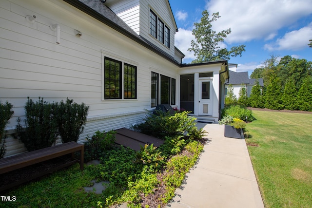 entrance to property featuring a lawn