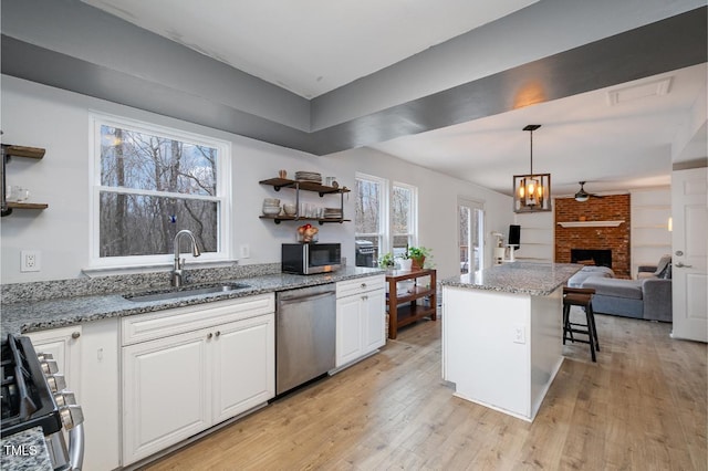 kitchen featuring appliances with stainless steel finishes, sink, white cabinets, and a kitchen breakfast bar