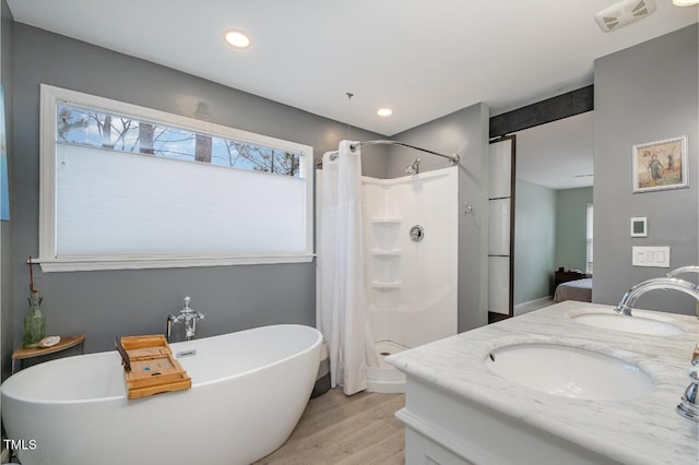 bathroom with vanity, wood-type flooring, and shower with separate bathtub