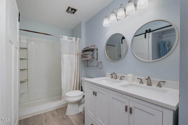 bathroom featuring vanity, hardwood / wood-style flooring, toilet, and a shower with shower curtain