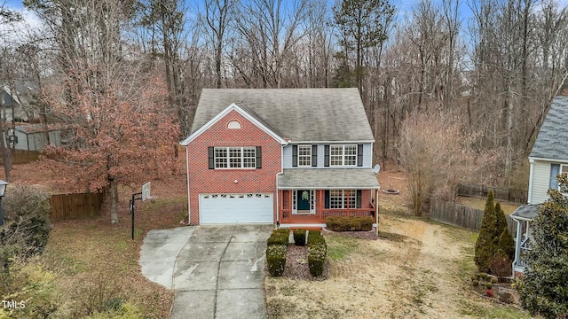 view of front of property featuring a garage, a front lawn, and a porch