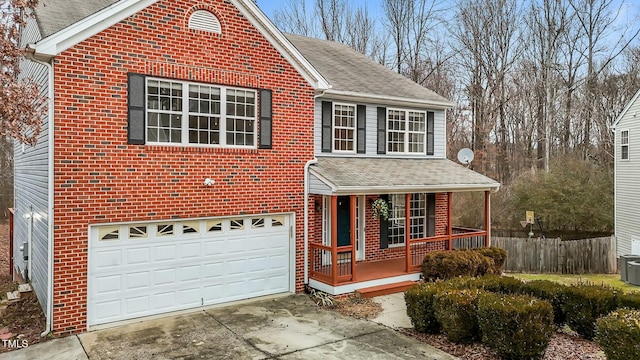 view of front property with central AC, a porch, and a garage