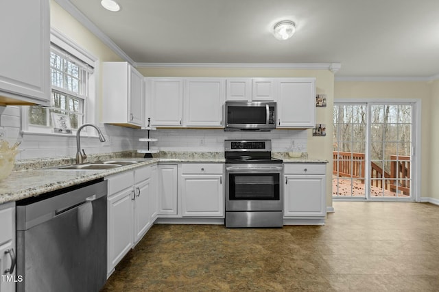 kitchen with sink, appliances with stainless steel finishes, white cabinets, light stone countertops, and backsplash