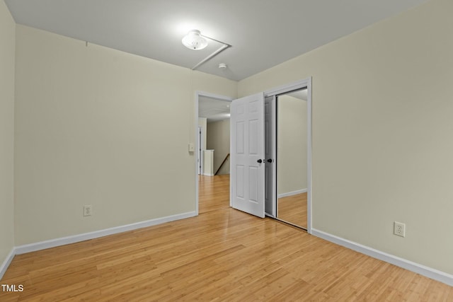 unfurnished bedroom with light hardwood / wood-style floors and a closet