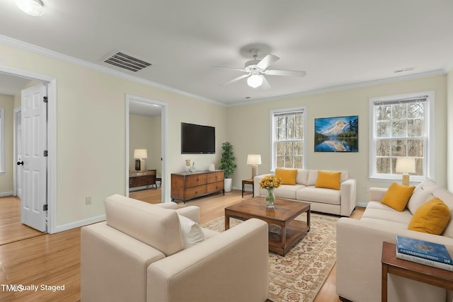 living room featuring ornamental molding, light hardwood / wood-style flooring, and a wealth of natural light