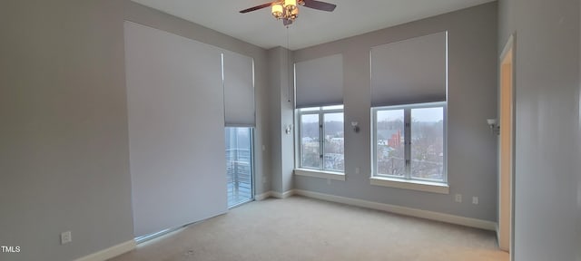 spare room with ceiling fan and light colored carpet