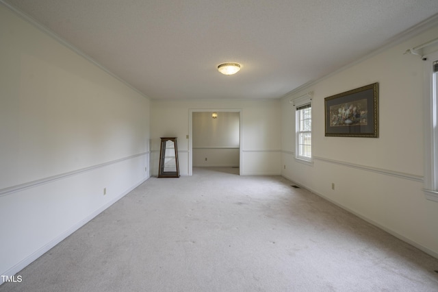 unfurnished room featuring crown molding, light colored carpet, and a textured ceiling