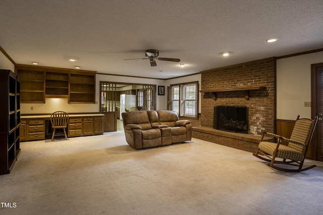 living room with ornamental molding, built in desk, light colored carpet, and a textured ceiling