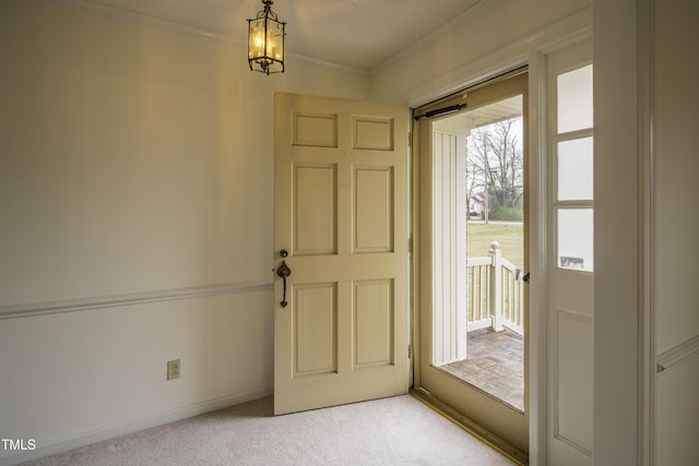 doorway to outside with crown molding and light colored carpet