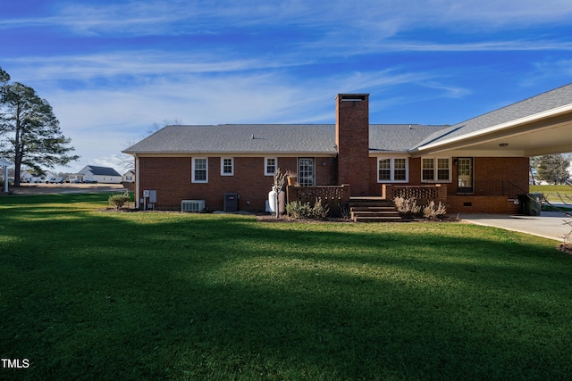 rear view of property with cooling unit and a yard