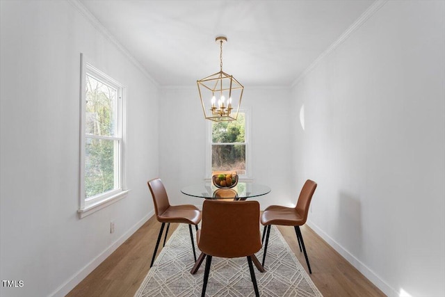 dining room featuring crown molding, light hardwood / wood-style flooring, and a wealth of natural light