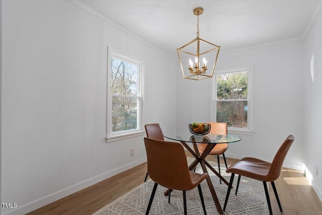 dining room featuring ornamental molding, a chandelier, light hardwood / wood-style floors, and a wealth of natural light