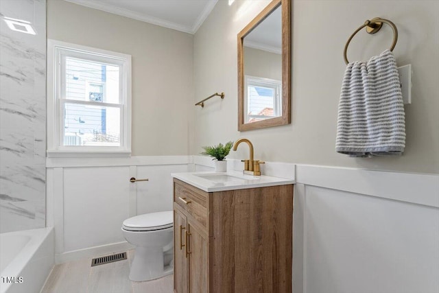 bathroom featuring crown molding, vanity, toilet, and a wealth of natural light