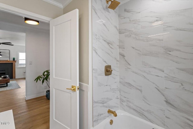 bathroom with ceiling fan, tiled shower / bath, ornamental molding, and hardwood / wood-style floors