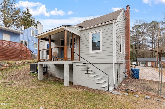 back of house with a yard and central AC