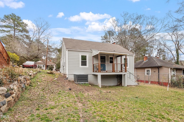 rear view of house with a yard and central AC