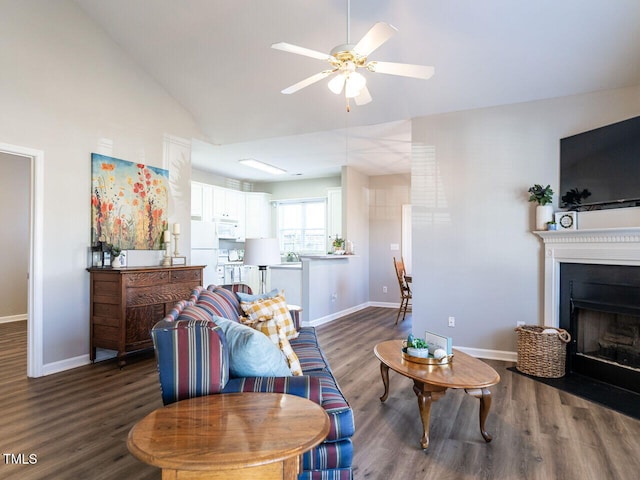 living area featuring dark wood finished floors, a fireplace, lofted ceiling, and baseboards