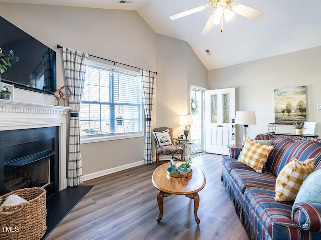 living room with visible vents, a fireplace, baseboards, and wood finished floors