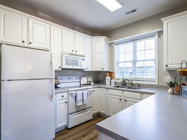 kitchen with white appliances, visible vents, white cabinets, dark wood-type flooring, and a sink