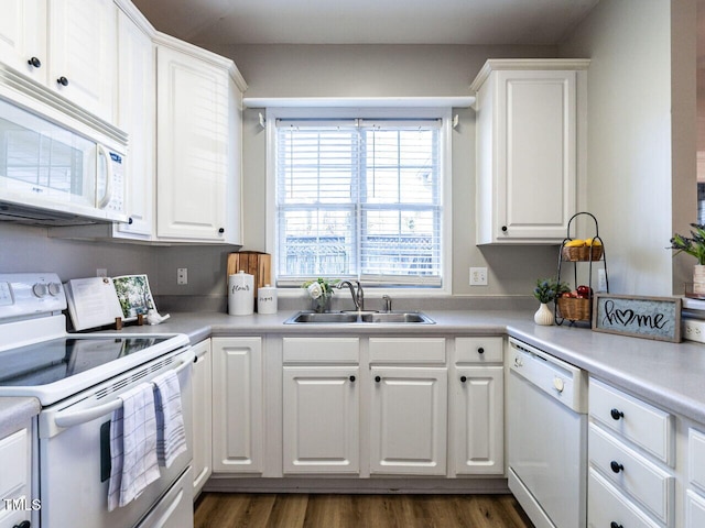 kitchen with light countertops, white appliances, white cabinetry, and a sink