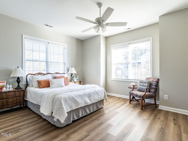 bedroom with visible vents, ceiling fan, baseboards, and wood finished floors