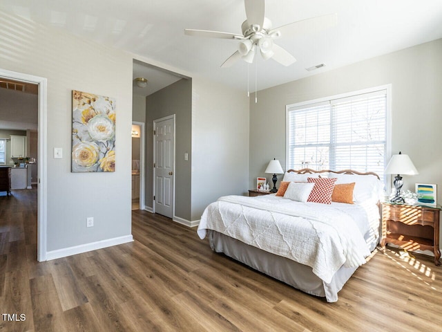 bedroom featuring baseboards, visible vents, and wood finished floors