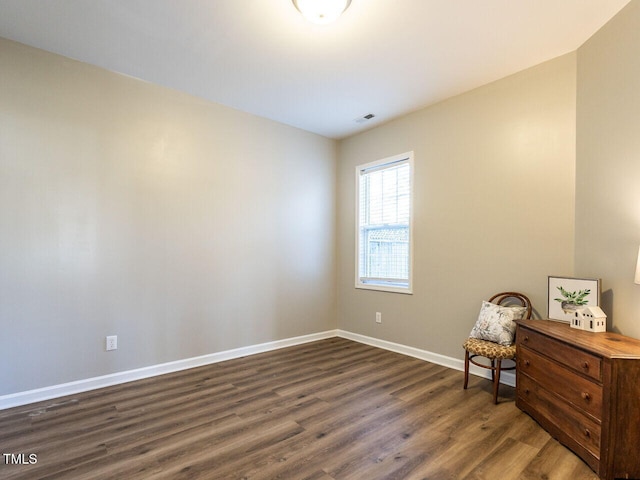 living area with baseboards, visible vents, and dark wood finished floors