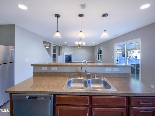 kitchen featuring sink, light tile patterned floors, hanging light fixtures, and stainless steel appliances