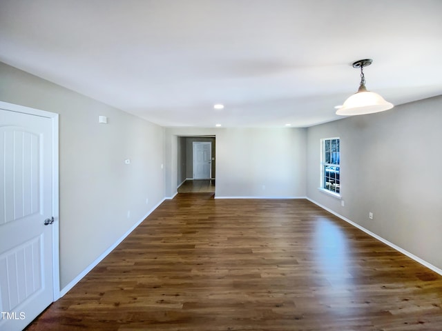 empty room with dark hardwood / wood-style flooring