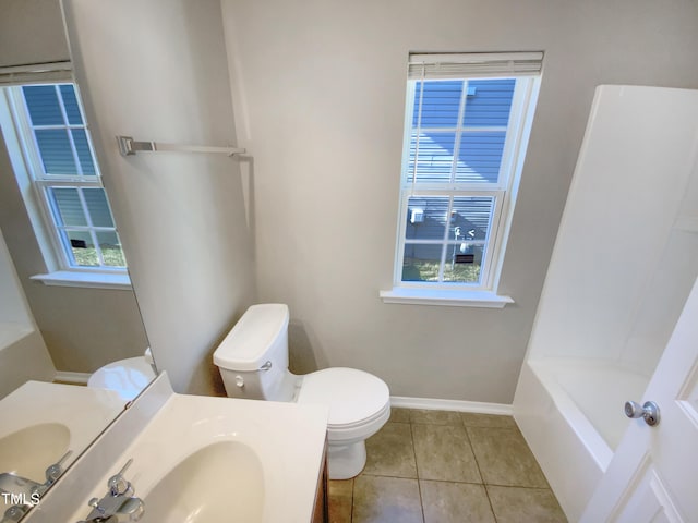 bathroom featuring vanity, toilet, a healthy amount of sunlight, and tile patterned flooring