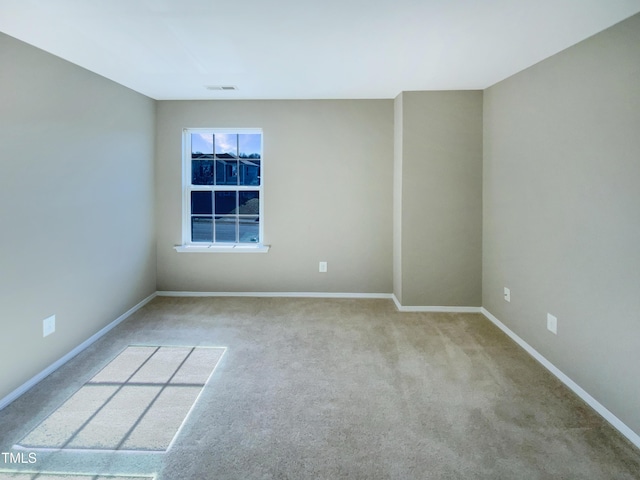 spare room featuring light colored carpet