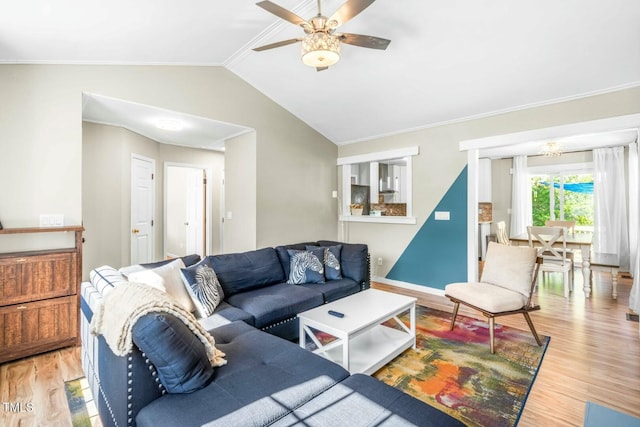 living room with ceiling fan, light hardwood / wood-style flooring, crown molding, and vaulted ceiling